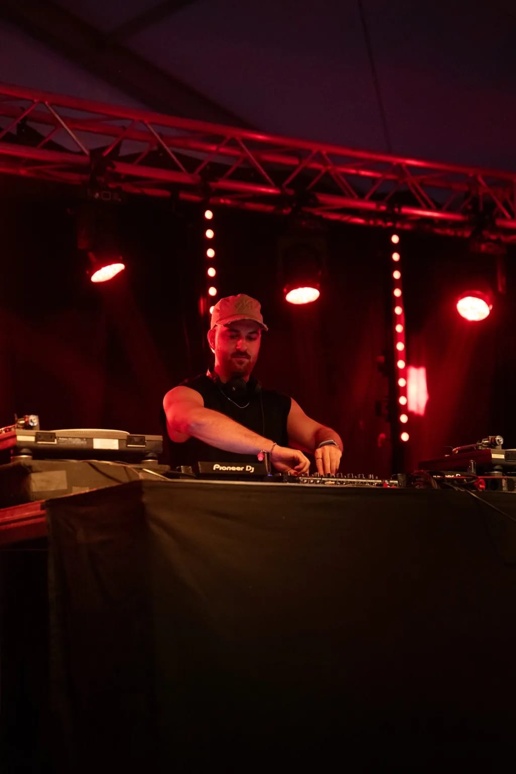 DJ aux platines sur la scène du Yadlo Festival, sous des projecteurs rouges