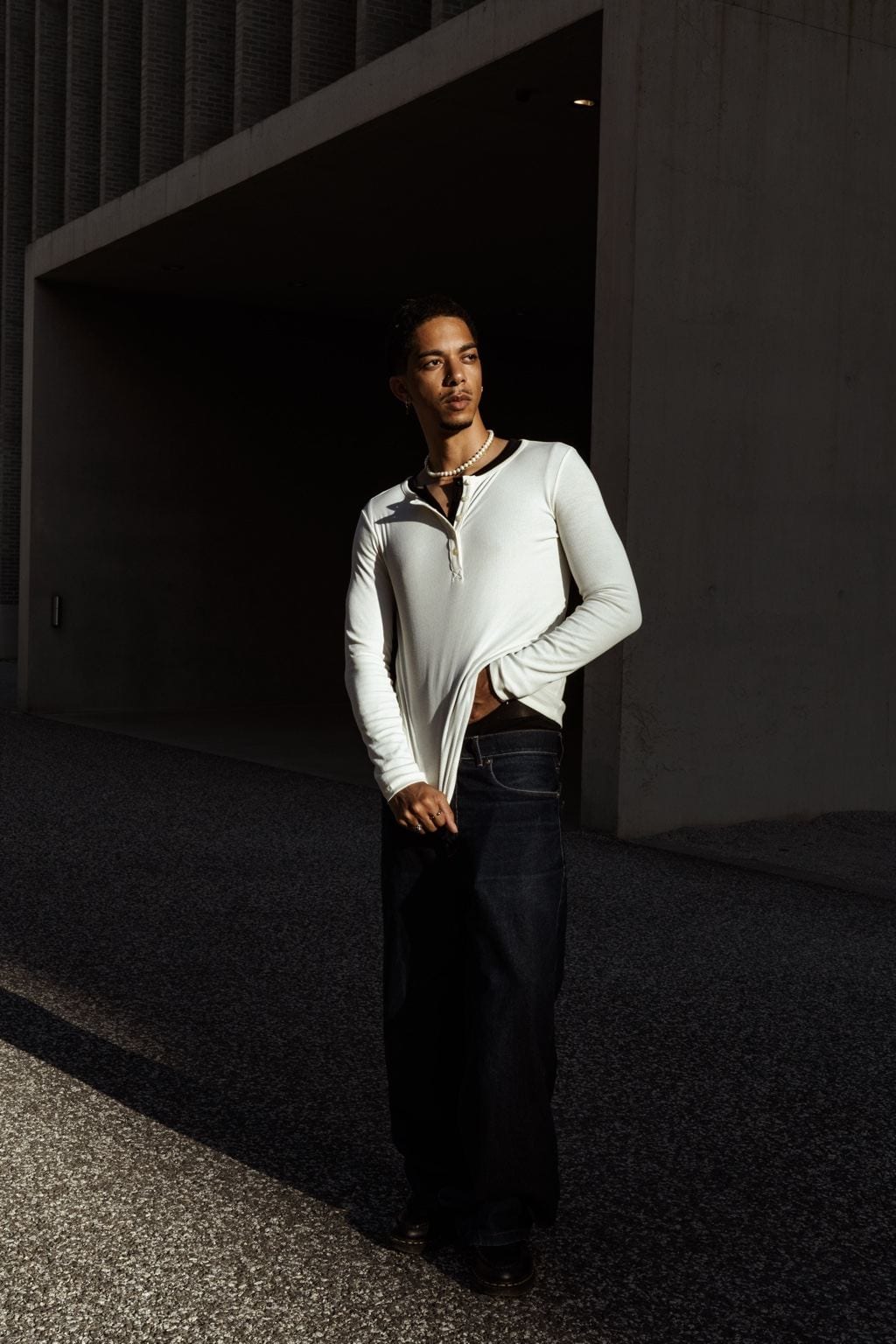 Amra en chemise blanche sous un passage couvert