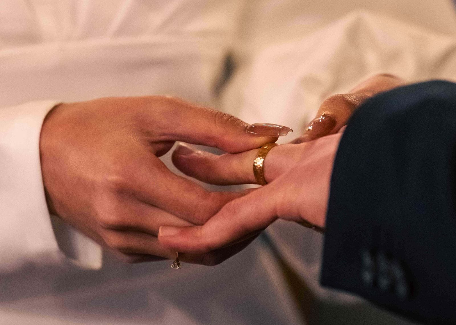 Échange des alliances : la mariée passe l'alliance au doigt du marié